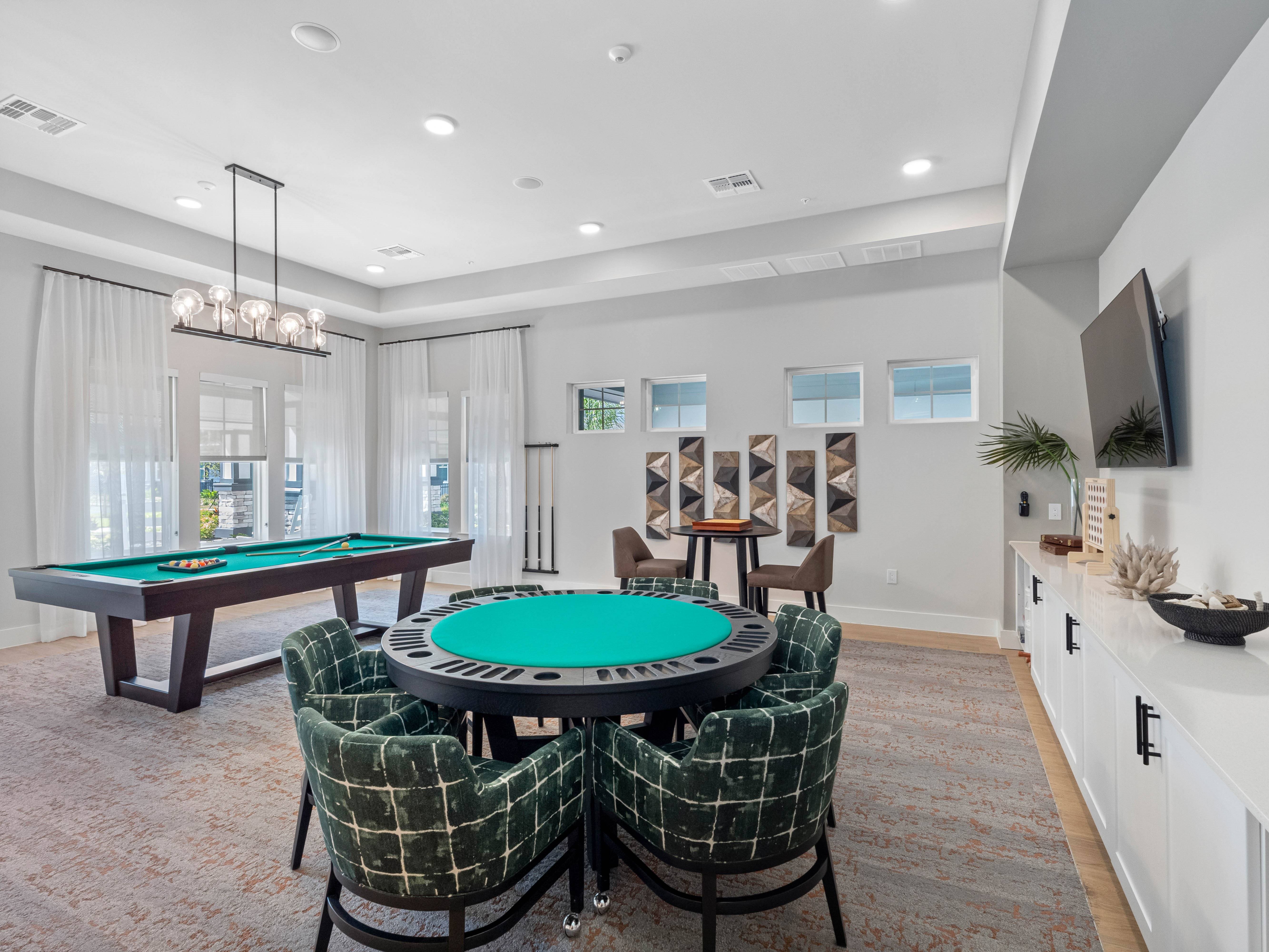 A room with a pool table and chairs.